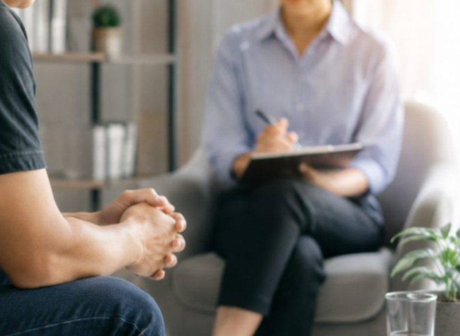 A counsellor taking notes during a session with a client